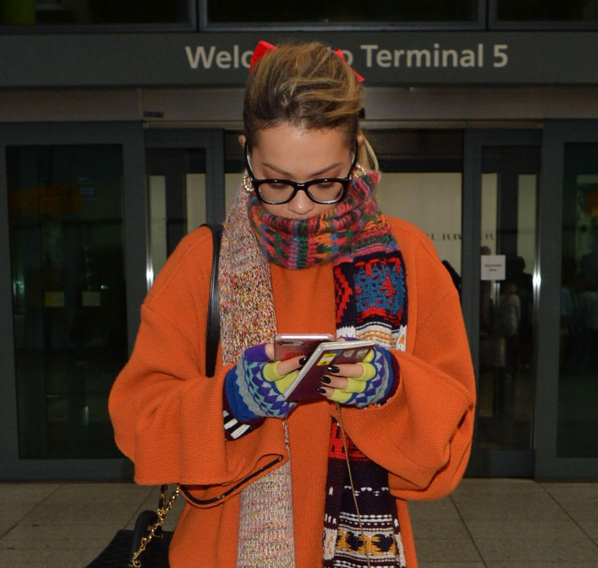 Rita Ora wears Orange Winter Top Stills at Heathrow Airport in London