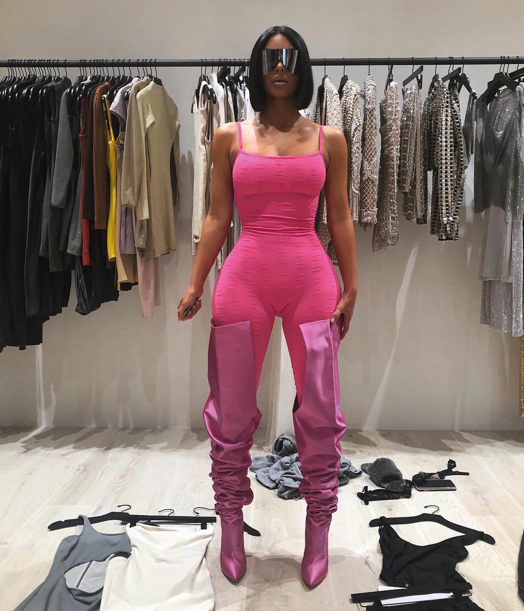 Kim Kardashian displays her figure in pink bodysuit and matching thigh-high boots