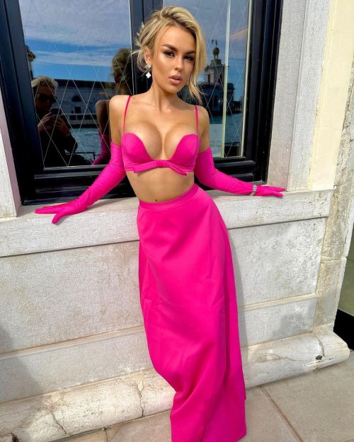 Tallia Storm accessorizing her Pink Dress with elegant jewelry and a sleek low ponytail at a fashion event in Venice