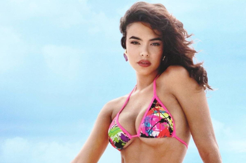 Bodine Koehler modeling pink multicolored print bikini top with dark wavy hair against blue sky backdrop for Playboy Latinoamérica 2025 summer edition