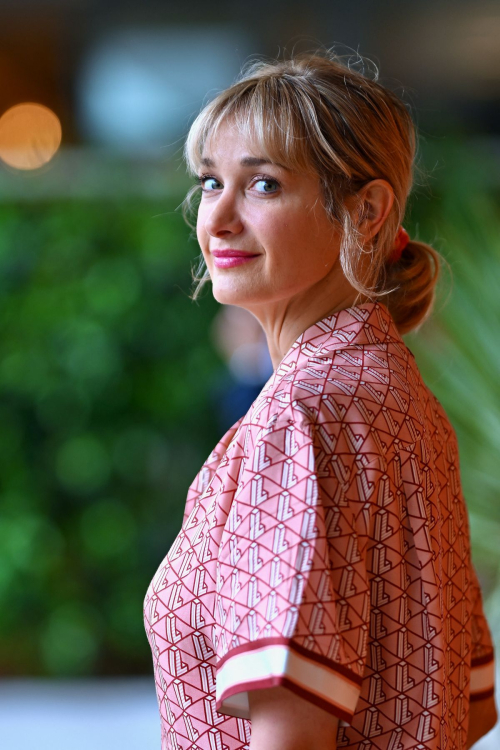 Close-up portrait of Caroline Anglade with elegant updo hairstyle and pink patterned outfit featuring geometric design at Roland Garros tennis tournament 2025
