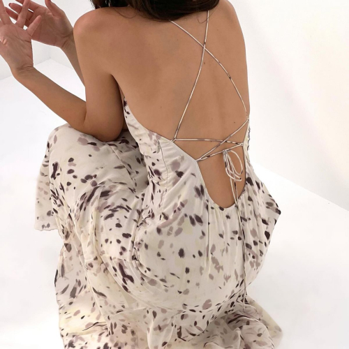 Model wearing cream floral print dress with open back and crisscross straps from EmRata line