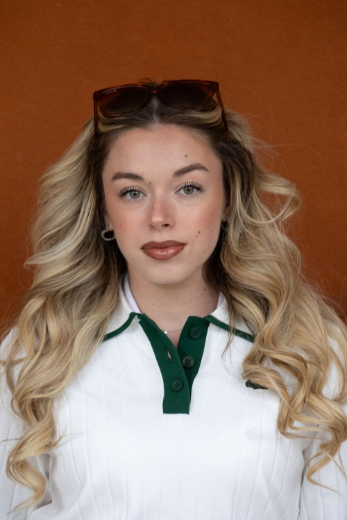 Close-up portrait of Emma Broyon sophisticated makeup look complementing her classic Lacoste white and green tennis ensemble at Roland Garros 2025