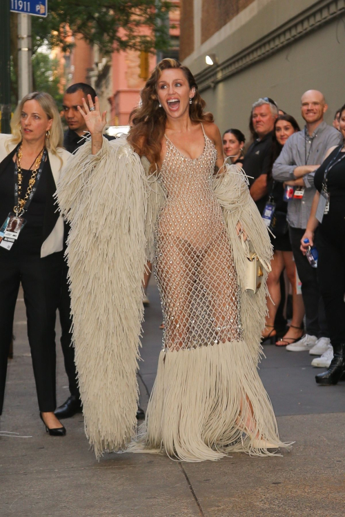 Miley Cyrus in diamond-patterned sheer dress with cream fringe details waving to crowd