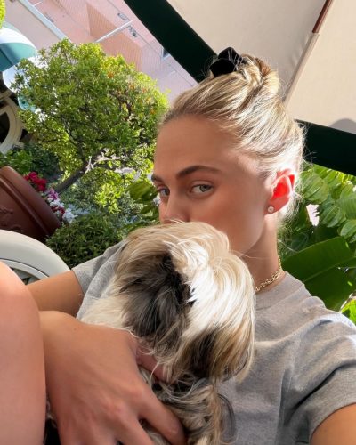 Alexa Serowik stylish orange dress with bold sunglasses reflecting sunlight.