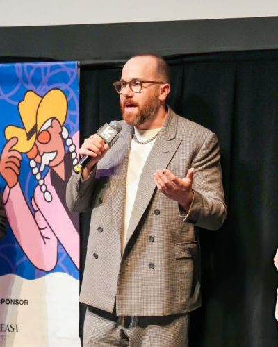 Allison Williams in black gown with tailored fit and sleek design.