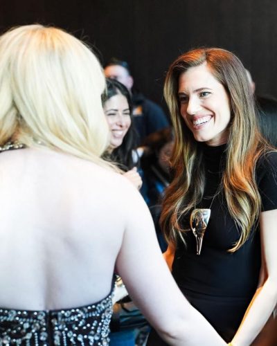 Allison Williams in a sophisticated black dress with a statement necklace.