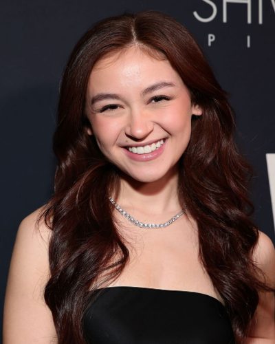 Anna Cathcart in a chic black dress with strappy heels.