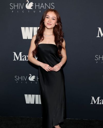 Anna Cathcart wearing a simple black dress and delicate necklace.