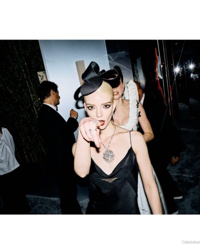 Anya Taylor-Joy black gown featuring a unique hat and prominent jewelry