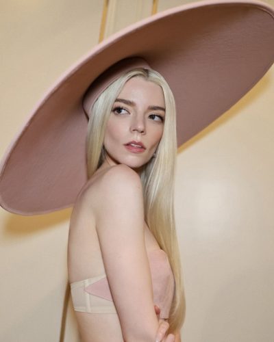 Anya Taylor-Joy styled in a pink cropped top and hat.