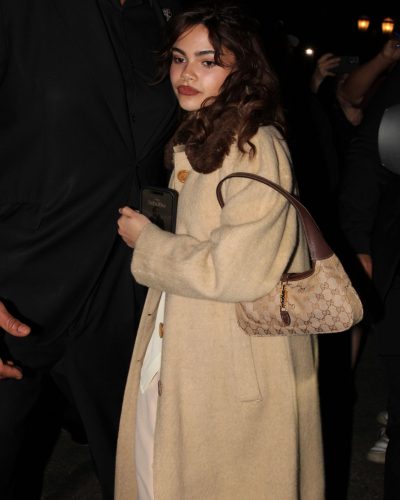 Ariana Greenblatt in a glamorous black gown with flowing fabric.