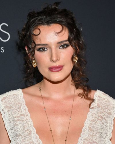 Bella Thorne sporting a sleek black dress with cascading curls.