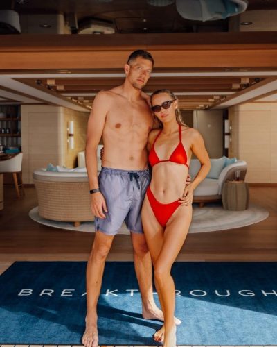 Caroline Wozniacki in trendy red bikini and minimal accessories by the water.