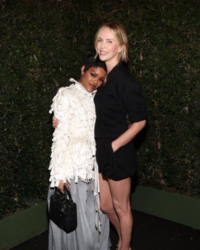 Charlize Theron black fitted shorts paired with lace trim top