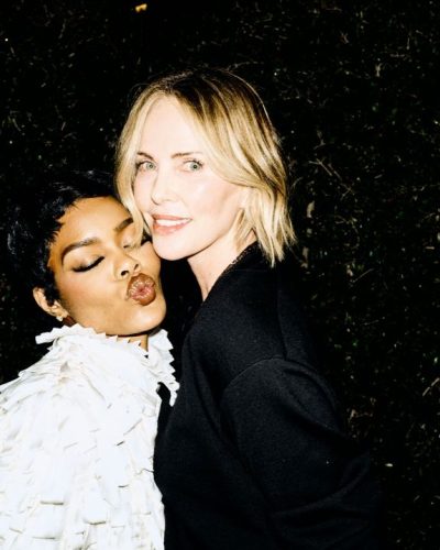 Charlize Theron black lace top and fitted black shorts ensemble