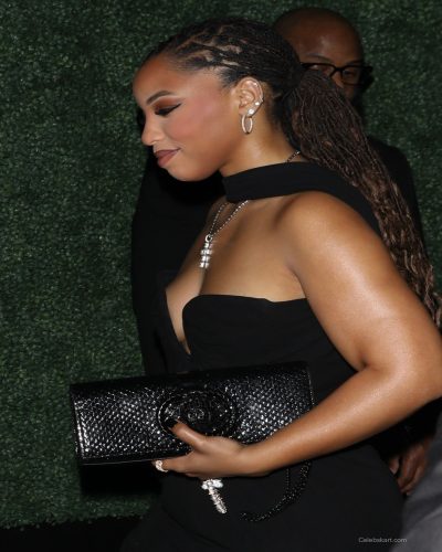 Chloe Bailey in a stylish black dress with bold jewelry
