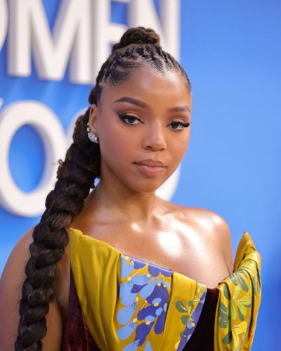 Chloe Bailey in burgundy velvet dress with cinched waist design.