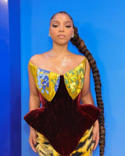 Chloe Bailey in elegant gown featuring deep burgundy and yellow.