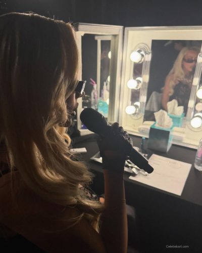 Christina Aguilera wearing black bodysuit with fluffy jacket