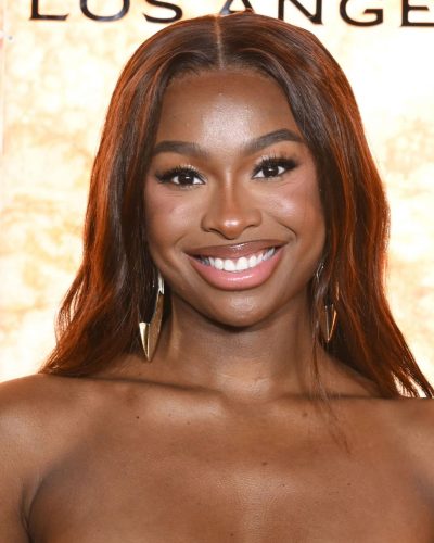 Coco Jones featuring warm tones in stylish black attire