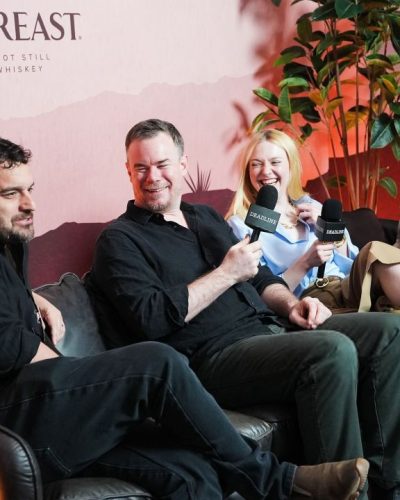 Debby Ryan in stylish black dress with floral patterns.