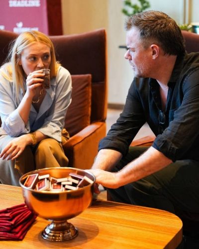 Dakota Fanning in simple light blue shirt and high-waisted trousers.