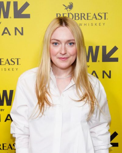 Dakota Fanning in cropped white shirt and black tailored skirt