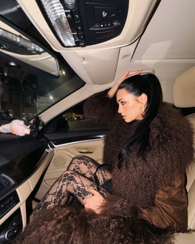 Daria Zaritskaya wearing brown faux fur coat over black lace leggings.