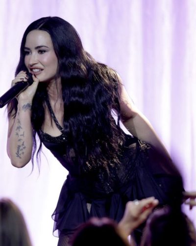 Demi Lovato wearing black lace bodysuit under ruffled skirt