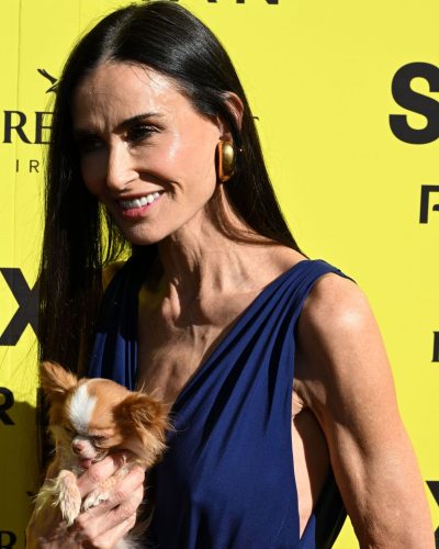 Demi Moore in a bold yellow gown with chunky gold bracelets.