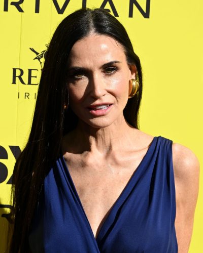 Demi Moore in a yellow dress featuring chunky gold bracelets.