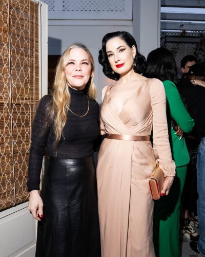 Dita Von Teese styled with a chic clutch and earrings.