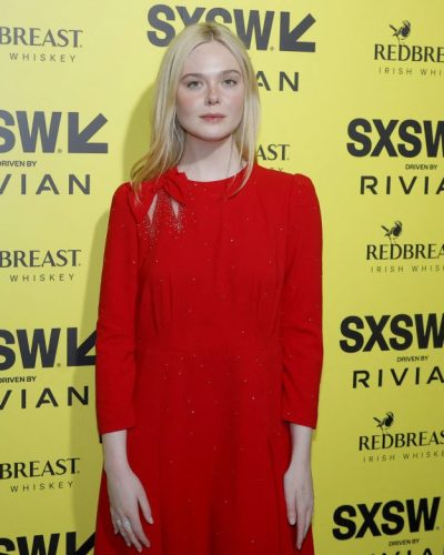 Elle Fanning in fashionable red gown with graceful flow