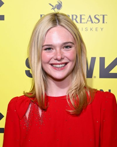 Elle Fanning wearing a bold red dress with graceful skirt design