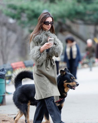 Emily Ratajkowski green trench coat paired with black wide-leg trousers.