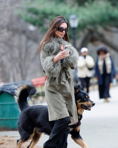 Emily Ratajkowski casual green coat with black wide-leg pants and shoes.