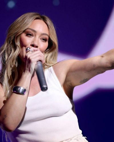 Hilary Duff in white tank top and light-colored shorts.