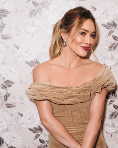 Hilary Duff with statement earrings paired with beige ruffled dress