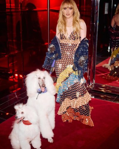 Kathryn Newton in colorful dress with eye-catching navy jacket