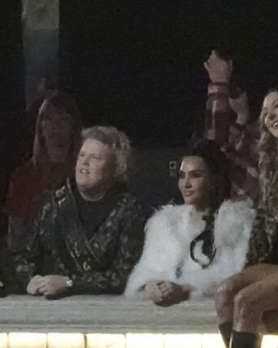 Kim Kardashian in black dress beneath white faux fur coat