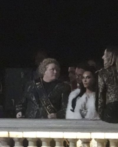 Kim Kardashian wearing sleek black dress under white faux fur coat