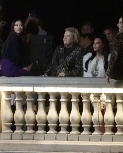 Kim Kardashian in white faux fur coat layered over black dress