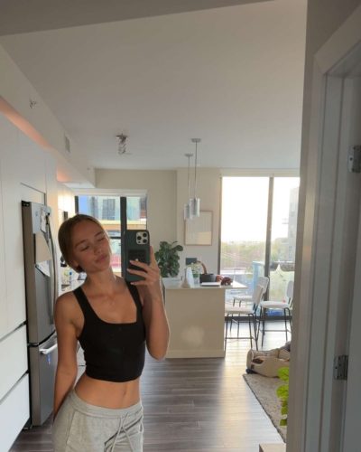 Kyla Dodds sporting a yellow sweater and light wash jeans.