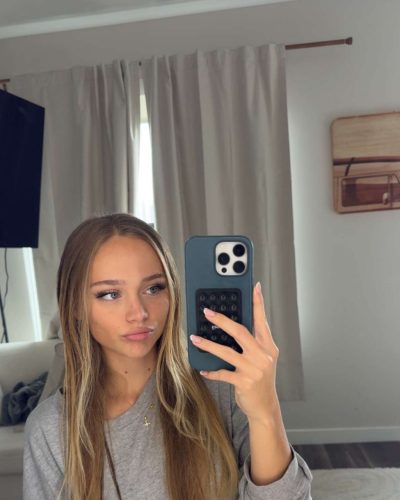 Kyla Dodds in light pink tank top, soft waves hairstyle.