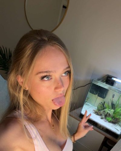 Kyla Dodds in light pink ribbed tank top and gold necklace.