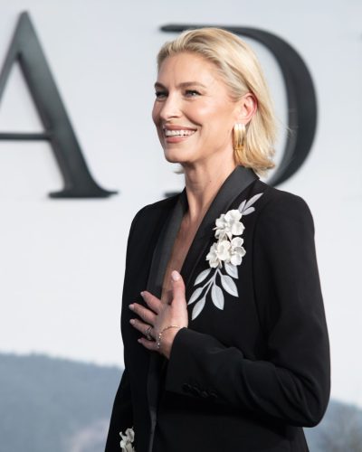 Louise Boyce black suit paired with elegant white handbag