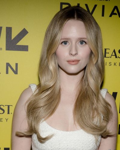 Lulu Wilson in a simple white dress with bold black heels