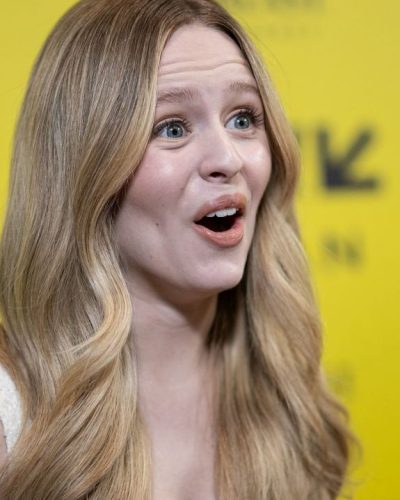 Lulu Wilson dressed in a white A-line dress and black shoes