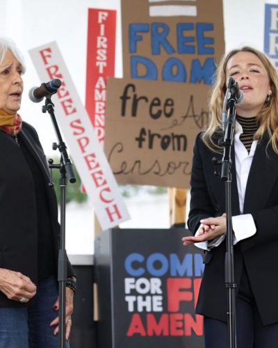 Maggie Rogers in a black blazer paired with a striped top.